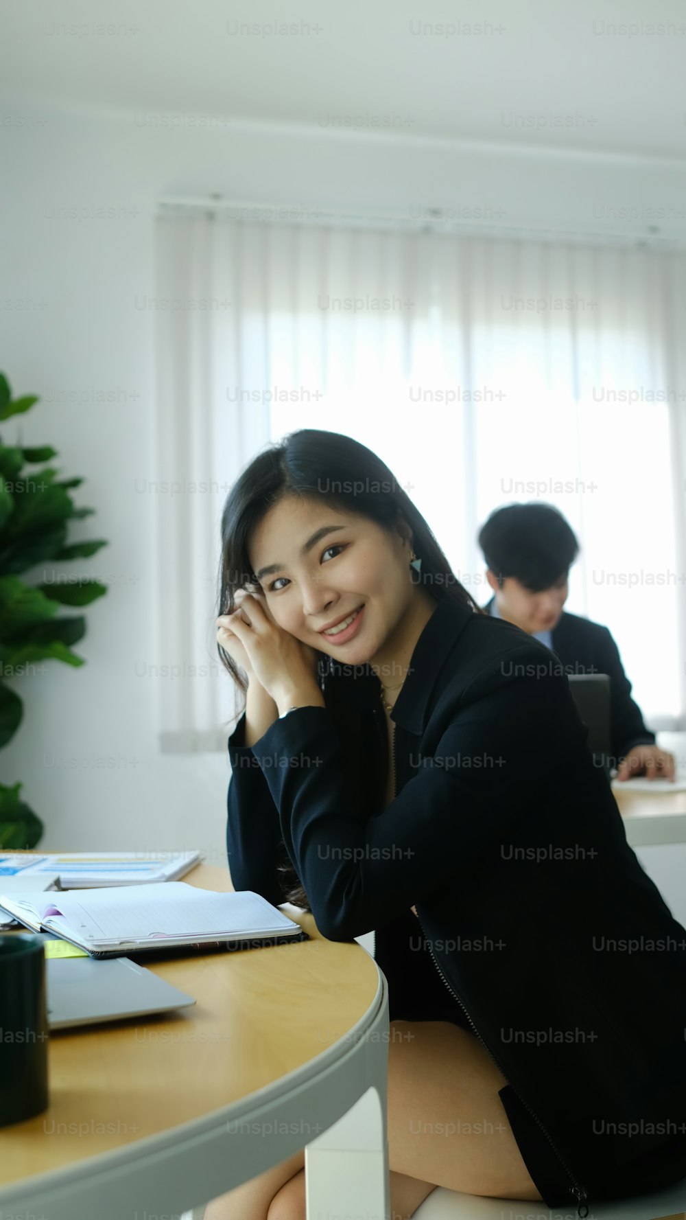 Portrait of attractive businesswoman smiling to camera while relaxing at her workplace.