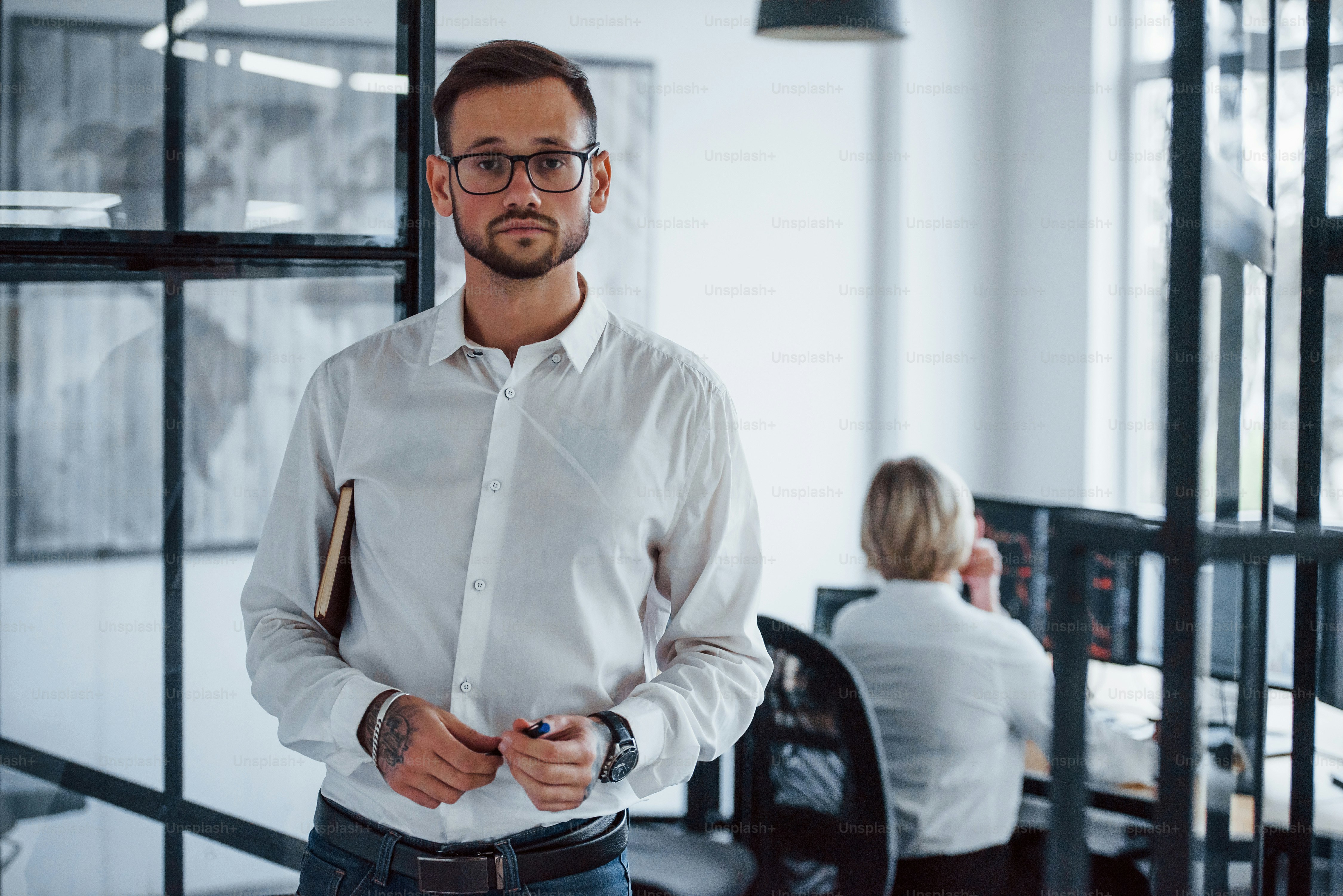Portrait of young businessman in formal clothes that stands in office.