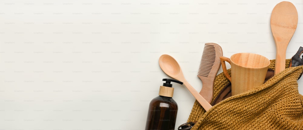 Zero waste concept, mock up scene with wooden kitchenware in wicker bag and copy space on white background