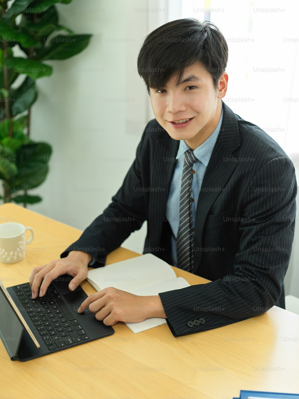 Portrait of businessman smiling to camera while working with digital tablet and business paperwork