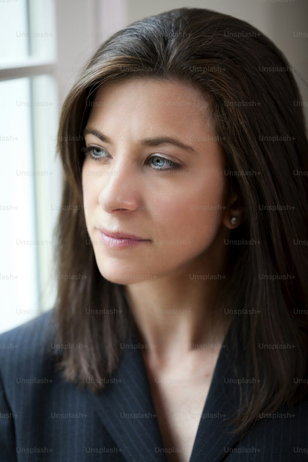 Attractive young woman in suit looking out of window