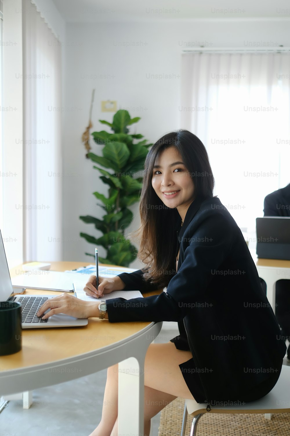 Portrait of attractive businesswoman working at her workplace and smiling to camera.