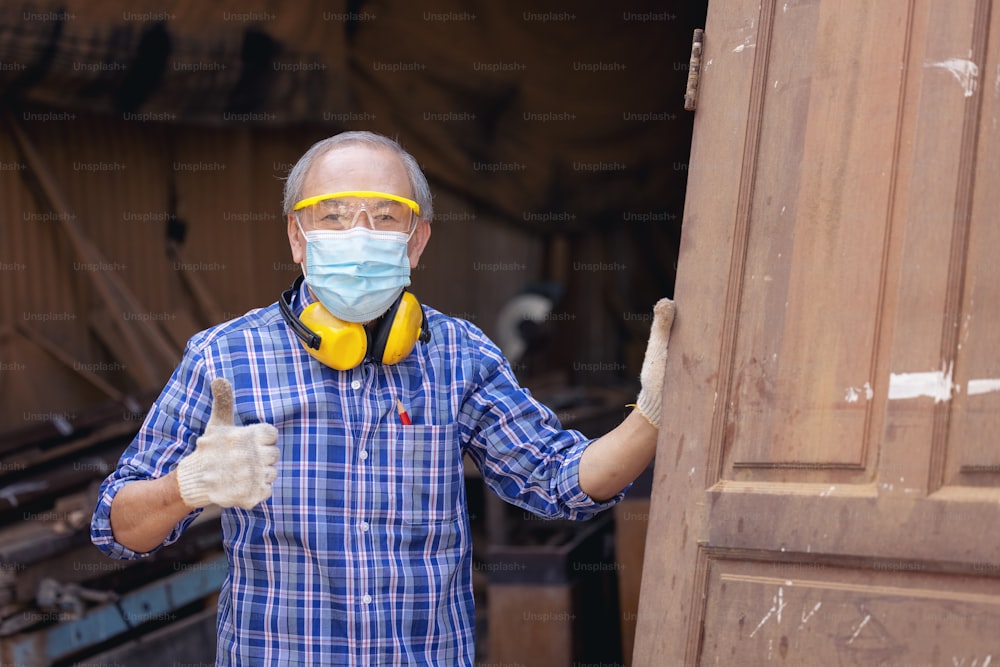 A mature carpenter standing confidently in his workshop