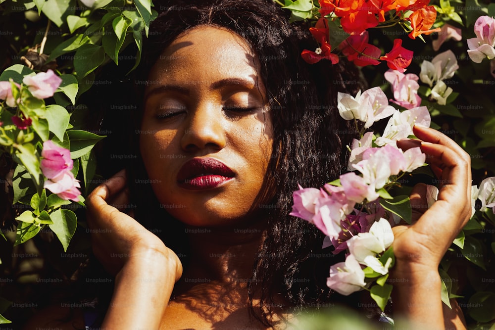 Content Black Woman Smelling with Flowers in Park.