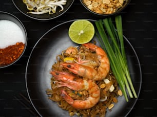 Top view of Thai food, stir fired Thai noodles with shrimps serving with lime, beansprouts and chives, Pad Thai