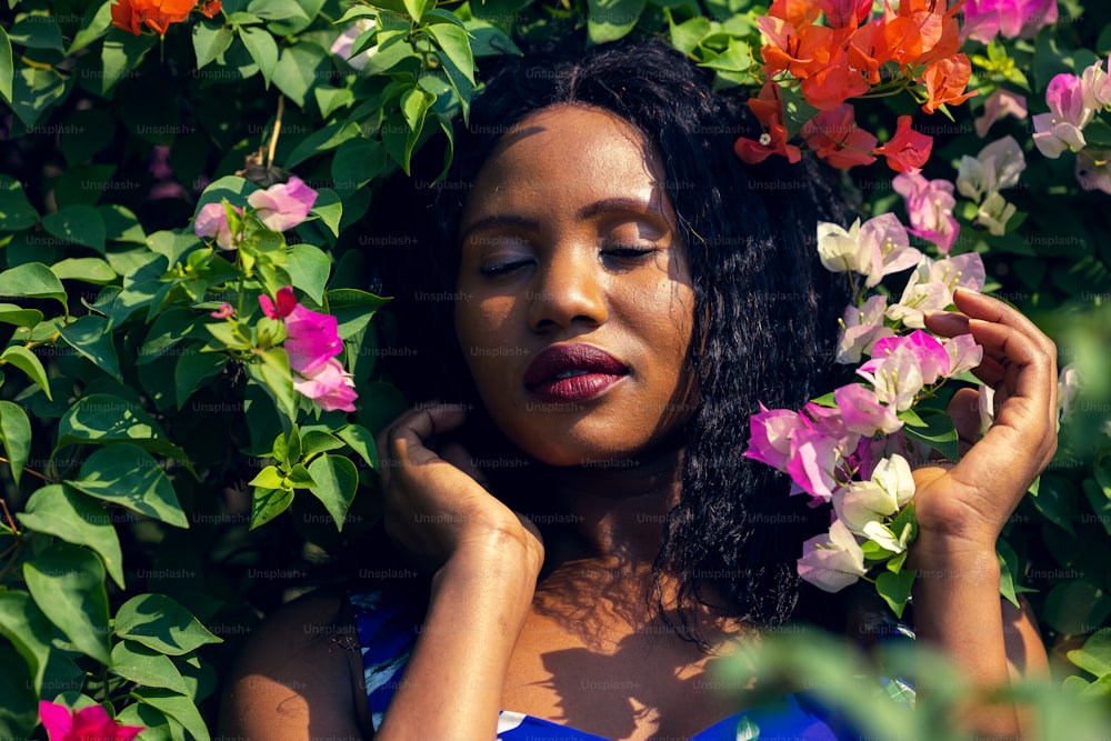 Content Black Woman Smelling with Flowers in Park.