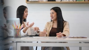 Happy coworkers discussing for new project planning in modern office.