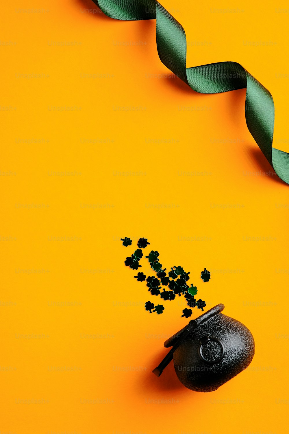 성 패트릭의 날 배너 디자인. 상위 뷰 녹색 리본, 주황색 배경에 토끼풀 모양의 색종이 냄비. 성 패트릭의 날 인사말 카드 템플릿