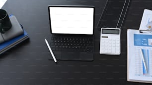 Overhead shot of accountant workplace with computer tablet calculate and business document on black office desk.