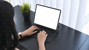 Cropped shot of businesswoman using computer tablet searching information online at office desk.