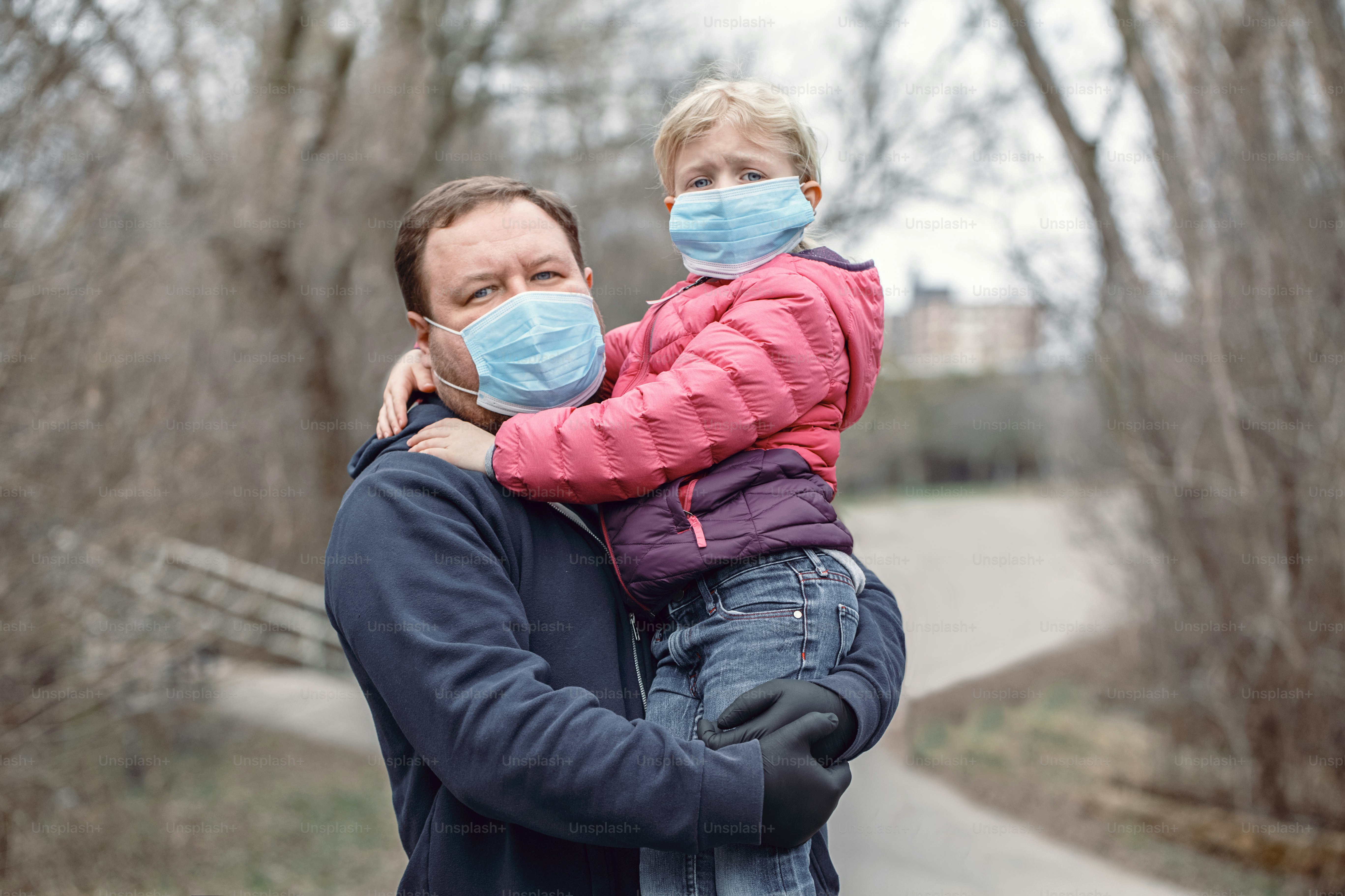 Caucasian father with child girl wearing sanitary face masks outdoor. Family dad and daughter protect themselves from dangerous spread of virus. Coronavirus COVID-19 quarantine.