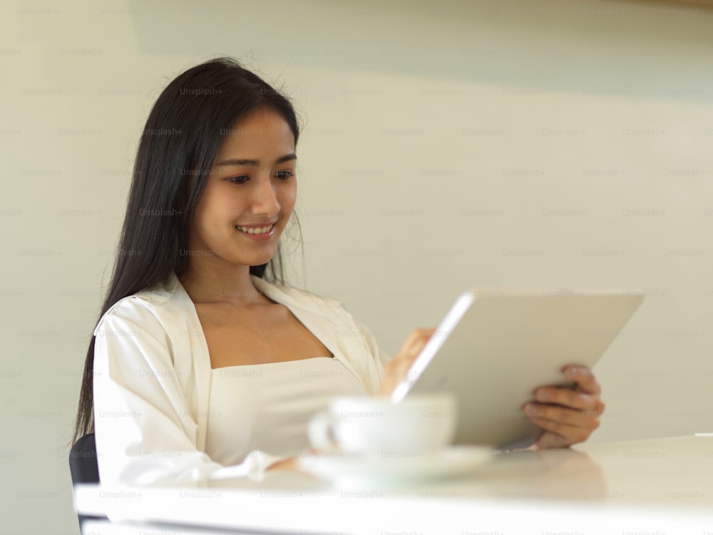 Portrait d’une femme d’affaires travaillant avec une tablette numérique assise dans un bureau