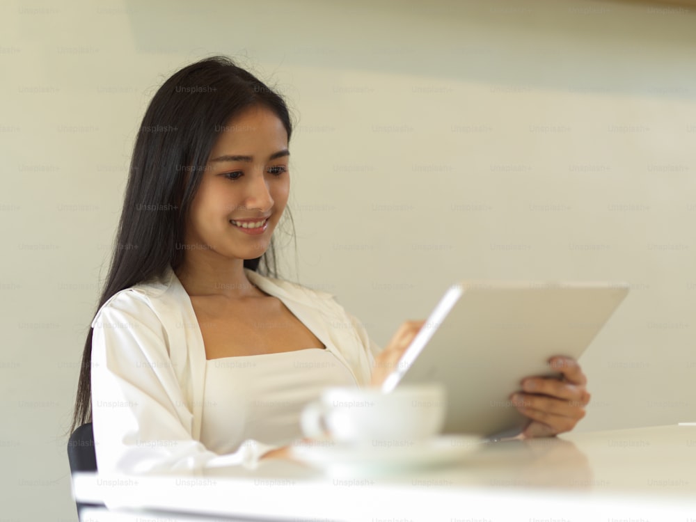 Portrait of businesswoman working with digital tablet while sitting in office room