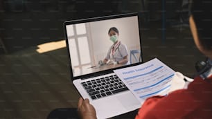 Close up view of mature woman patients using laptop computer having video call consult with female doctor at home.
