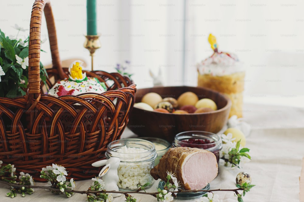 축복을위한 전통 부활절 음식, 수제 부활절 빵, 세련된 부활절 달걀 및 소박한 테이블의 린넨 냅킨에 피는 봄 꽃. 행복한 부활절! 축제 아침 식사