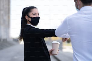 Portrait of two business people bumping elbows for greeting each other outdoors. Business concept. New normal lifestyle concept.