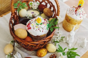 Nourriture traditionnelle de Pâques pour la bénédiction, pain de Pâques fait maison, œufs de Pâques élégants et fleurs printanières épanouies sur une serviette en lin sur une table rustique. Joyeuses Pâques ! Petit-déjeuner festif