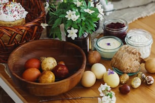 세련된 부활절 달걀, 수제 부활절 빵, 맛있는 전통 부활절 음식, 소박한 테이블에 피는 봄 꽃. 행복한 부활절! 축제 아침 식사