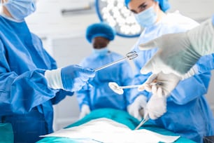 Prise de vue en contre-plongée dans la salle d’opération, l’assistant distribue des instruments aux chirurgiens pendant l’opération. Les chirurgiens effectuent l’opération. Médecins professionnels pratiquant la chirurgie.