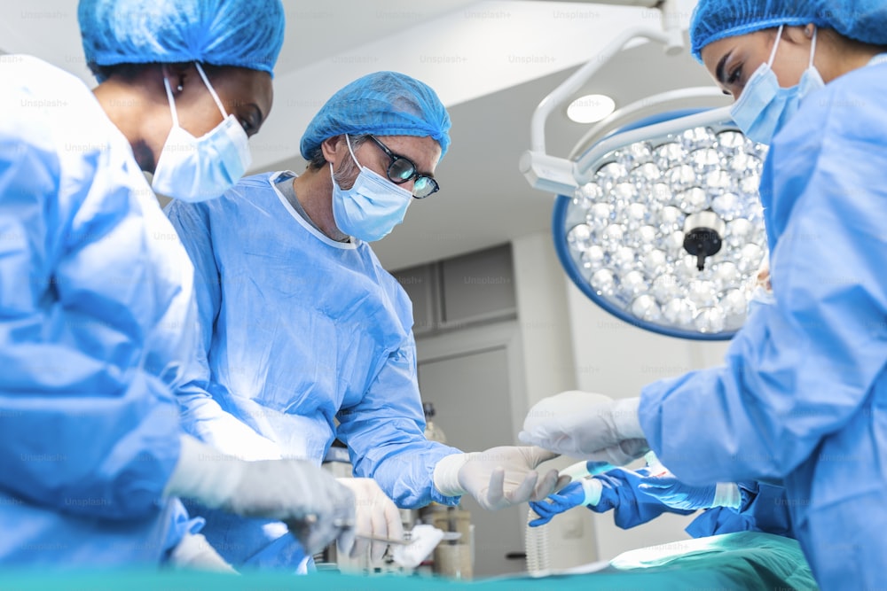 Cirujanos operando en quirófano. Cirugía de aumento de pecho en quirófano Herramientas de cirujano implante. Concepto de atención médica.