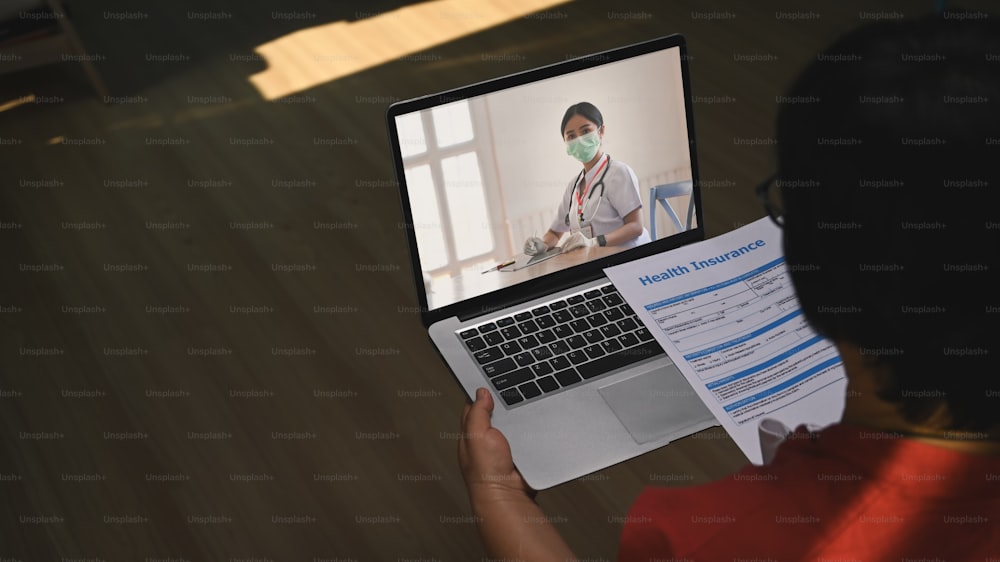 Mature woman patients using computer laptop for online consultation with doctor via video call at home. Online medical consultation.