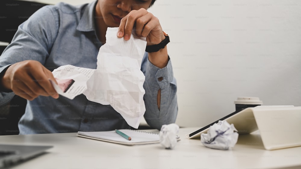 Cropped shot of disappointed businessman has trouble and tearing document.