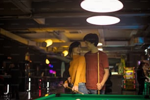 Young couple spending time in billiard room. Time for competition.