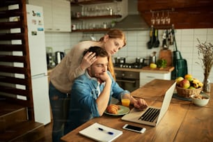 Nachdenklicher Freiberufler und seine Frau lesen eine E-Mail auf einem Computer, während sie zu Hause arbeiten.