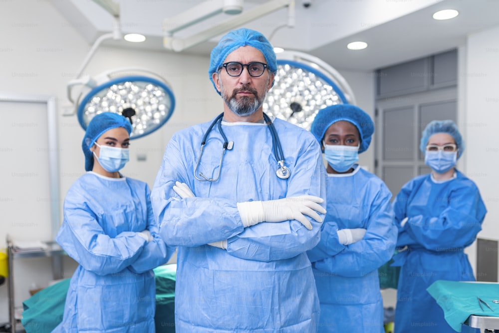 Group of medical surgeons wearing hospital scrubs in operating theatre. Portrait of successful medical workers in surgical uniform in operation theater, ready for next operation.