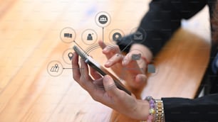 Close up view of businesswoman holding smartphone with application icons around.