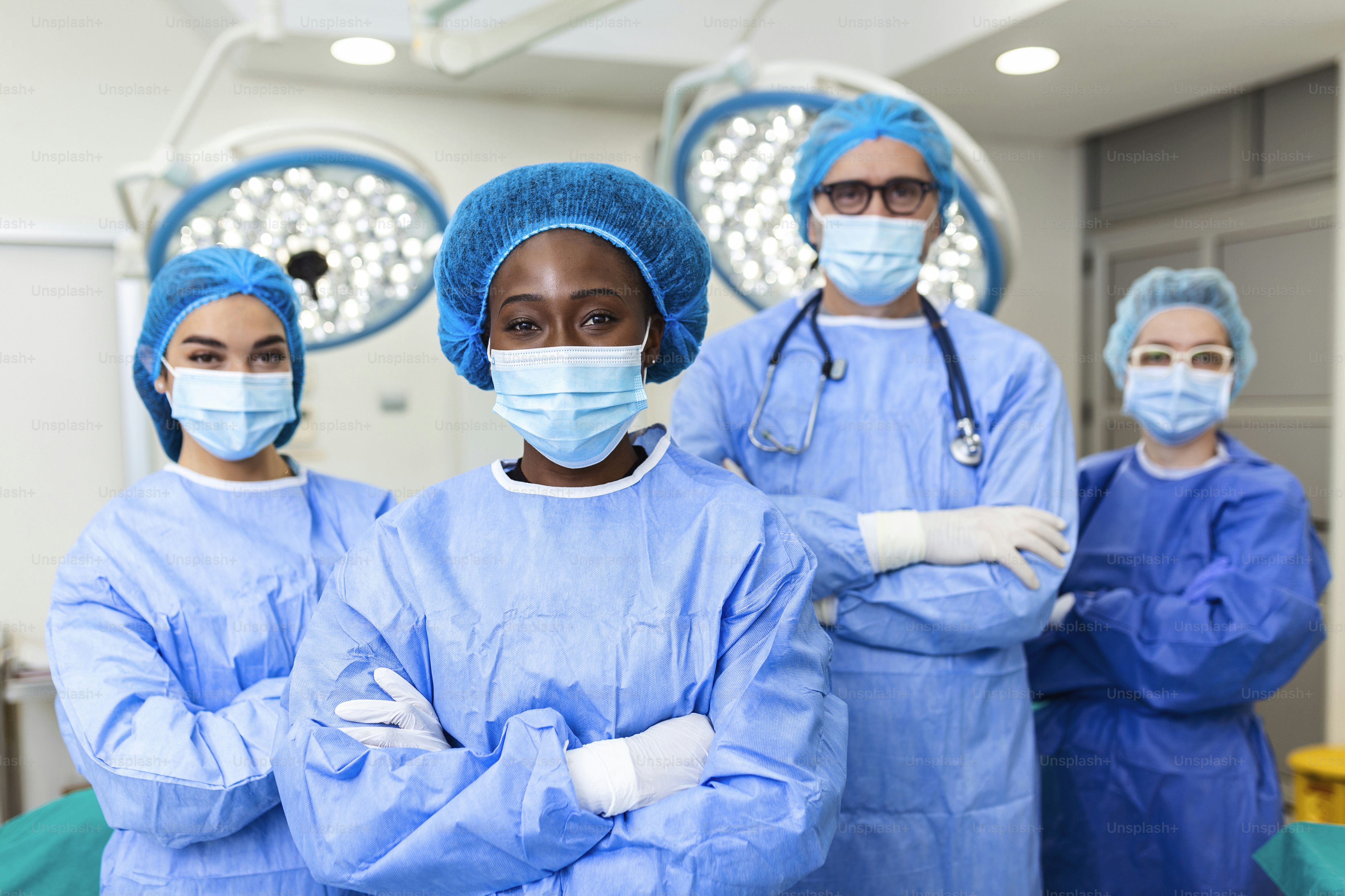 Portrait Of Multi-Cultural Medical Team Standing In operating theatre. Portrait of successful medical workers in surgical uniform in operation theater, ready for next operation.