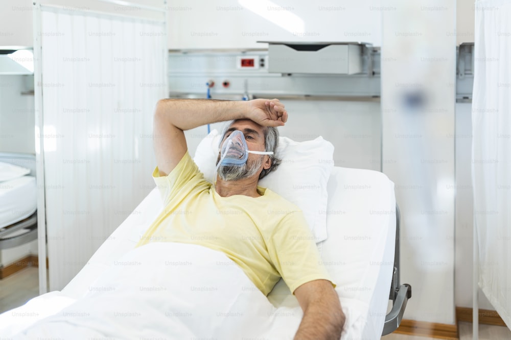 Portrait of retired senior man breathing slowly with oxygen mask during coronavirus covid-19 outbreak. Old sick man lying in hospital bed, getting treatment for deadly infection