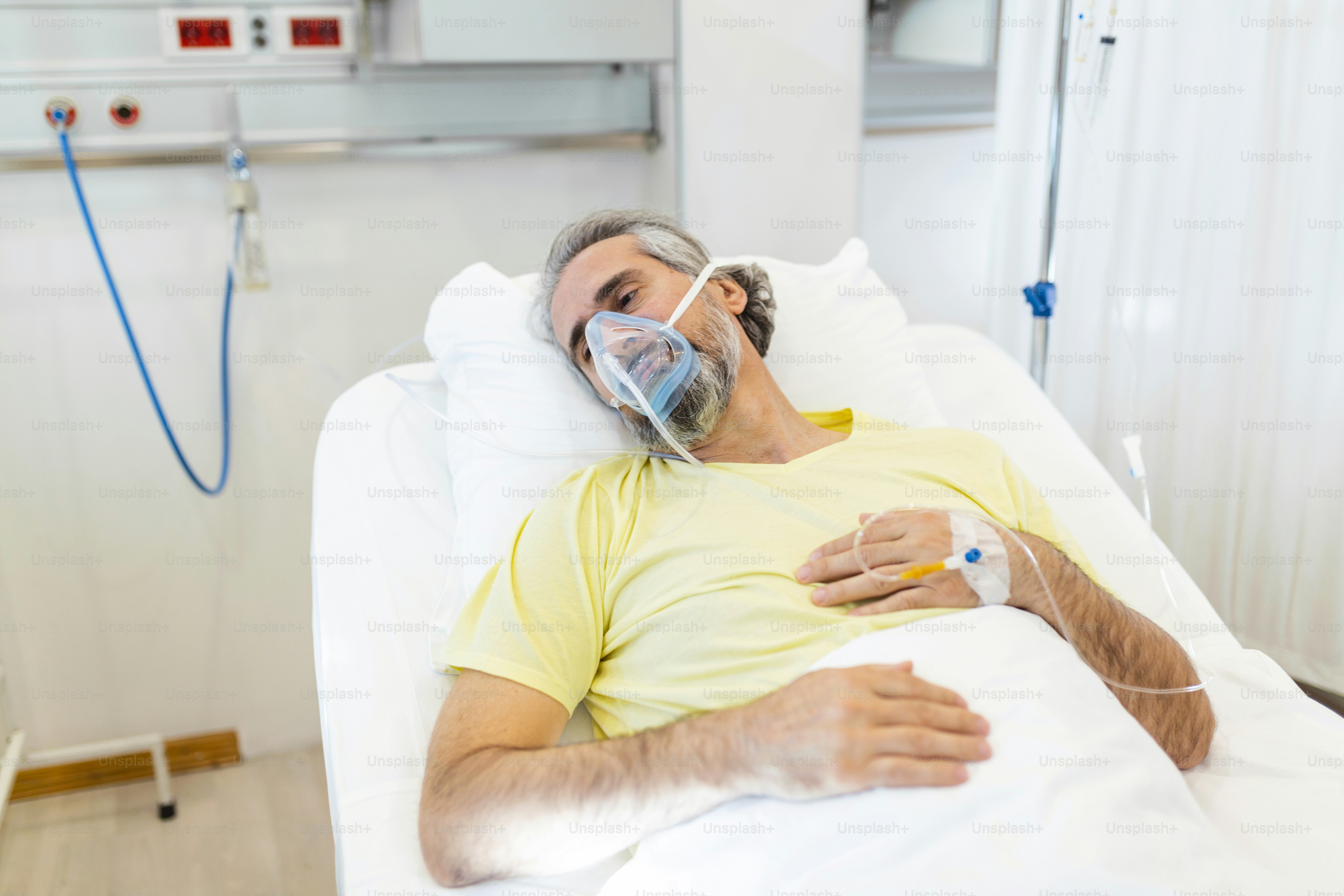 No Hospital Idoso Covid-19 Paciente Descansa, Deitado na Cama com máscara de oxigênio. Homem em recuperação dormindo na enfermaria do hospital moderno