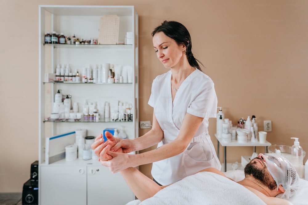 Esthetician or facialist gives a relaxing facial massage to a man