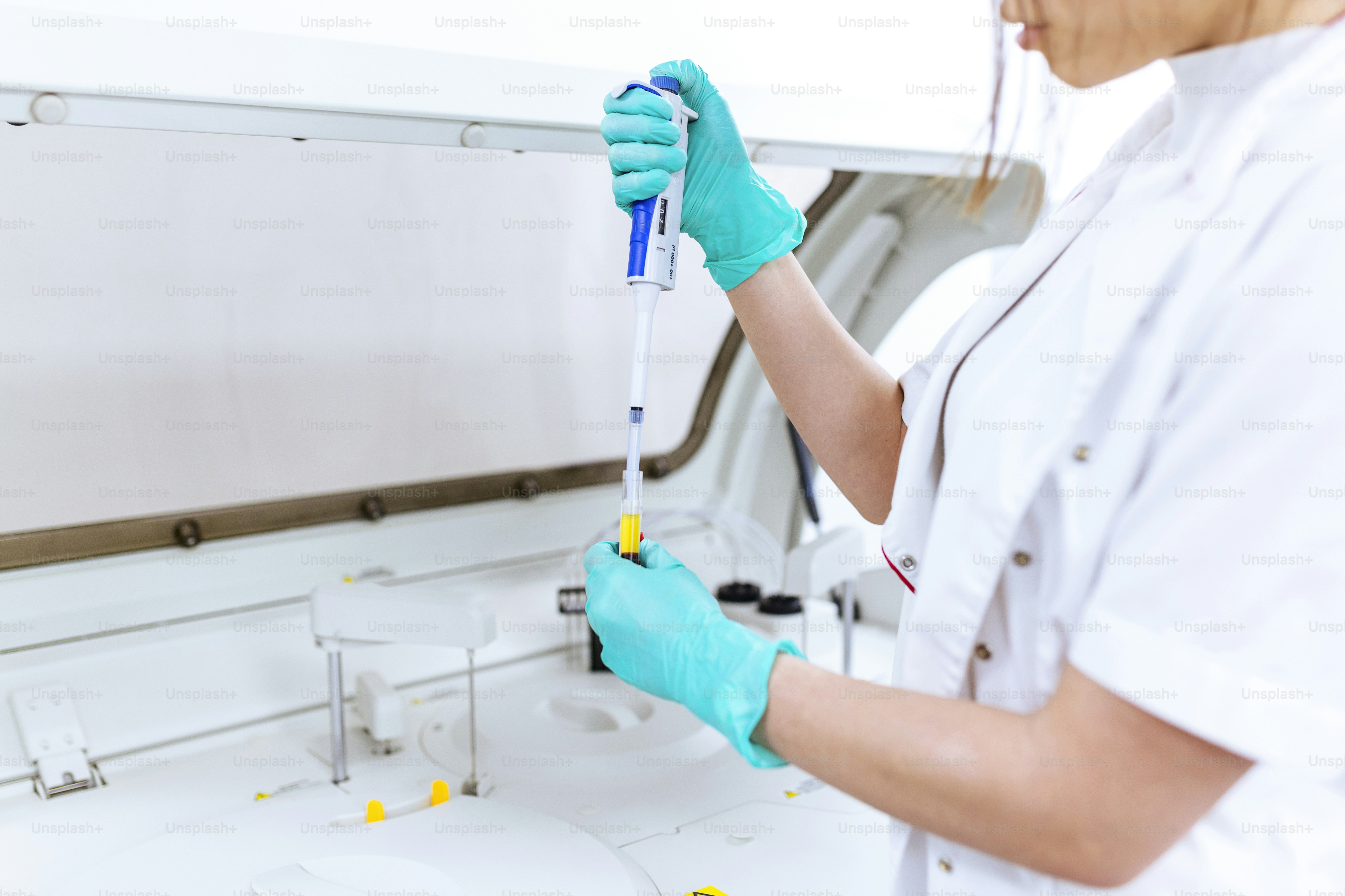 Interior of clean modern white medical or chemistry laboratory background. Laboratory scientist working at a lab with micro pipette and test tubes. Laboratory concept with woman chemist.