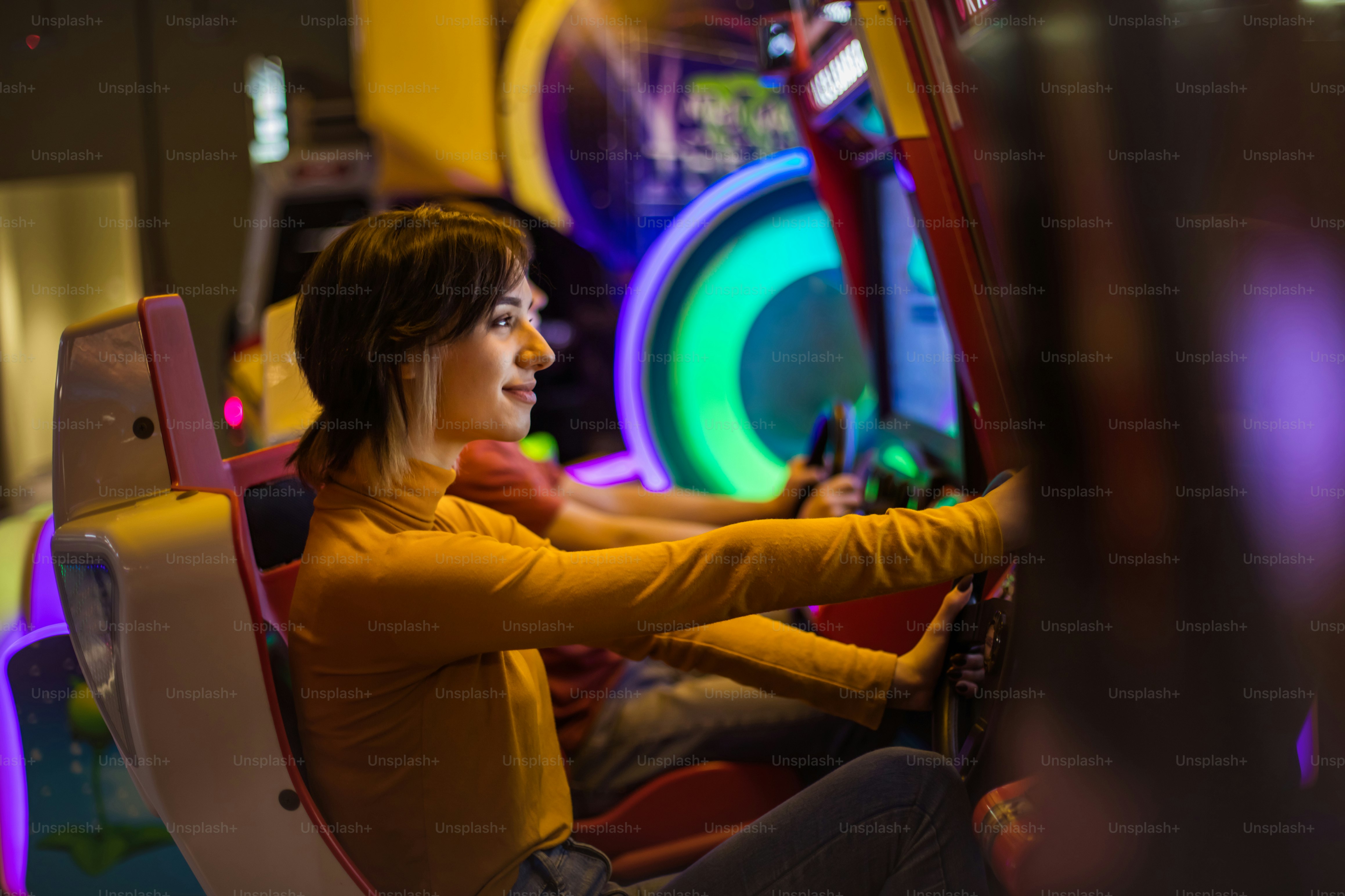 Pareja divirtiéndose en la sala de juegos. Jugando un juego.  La atención se centra en la mujer.