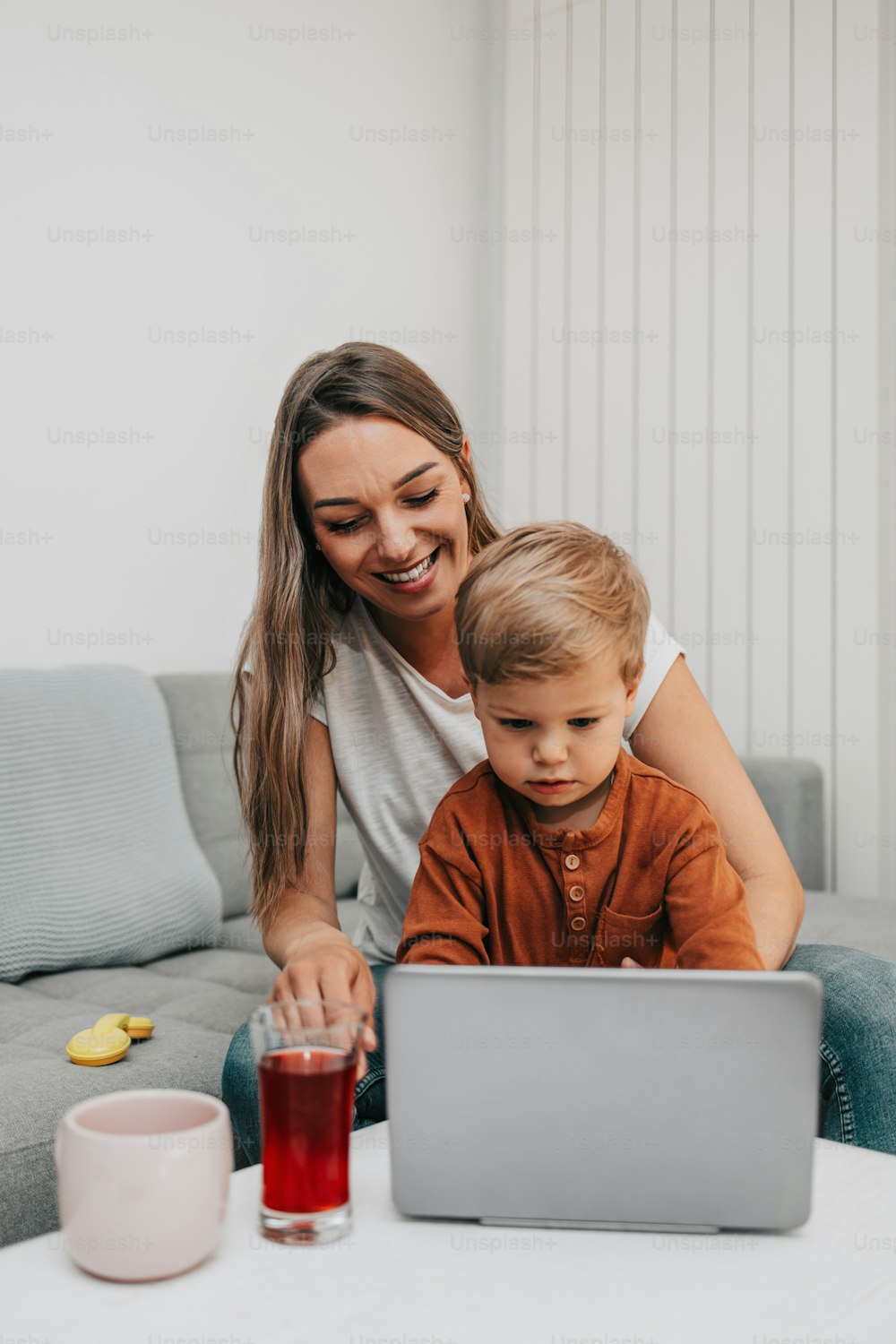 Happy mother with her little son and dog enjoying in online shopping or working from home. Business from distance and virtual communication.