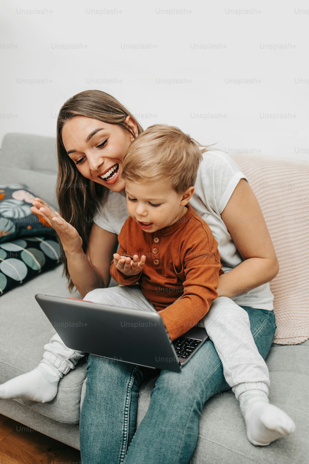 Happy mother with her little son and dog enjoying in online shopping or working from home. Business from distance and virtual communication.