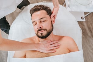 Esthetician or facialist gives a relaxing facial massage to a man