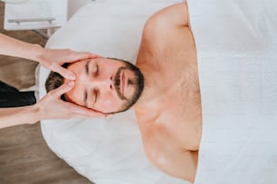 Esthetician or facialist gives a relaxing facial massage to a man