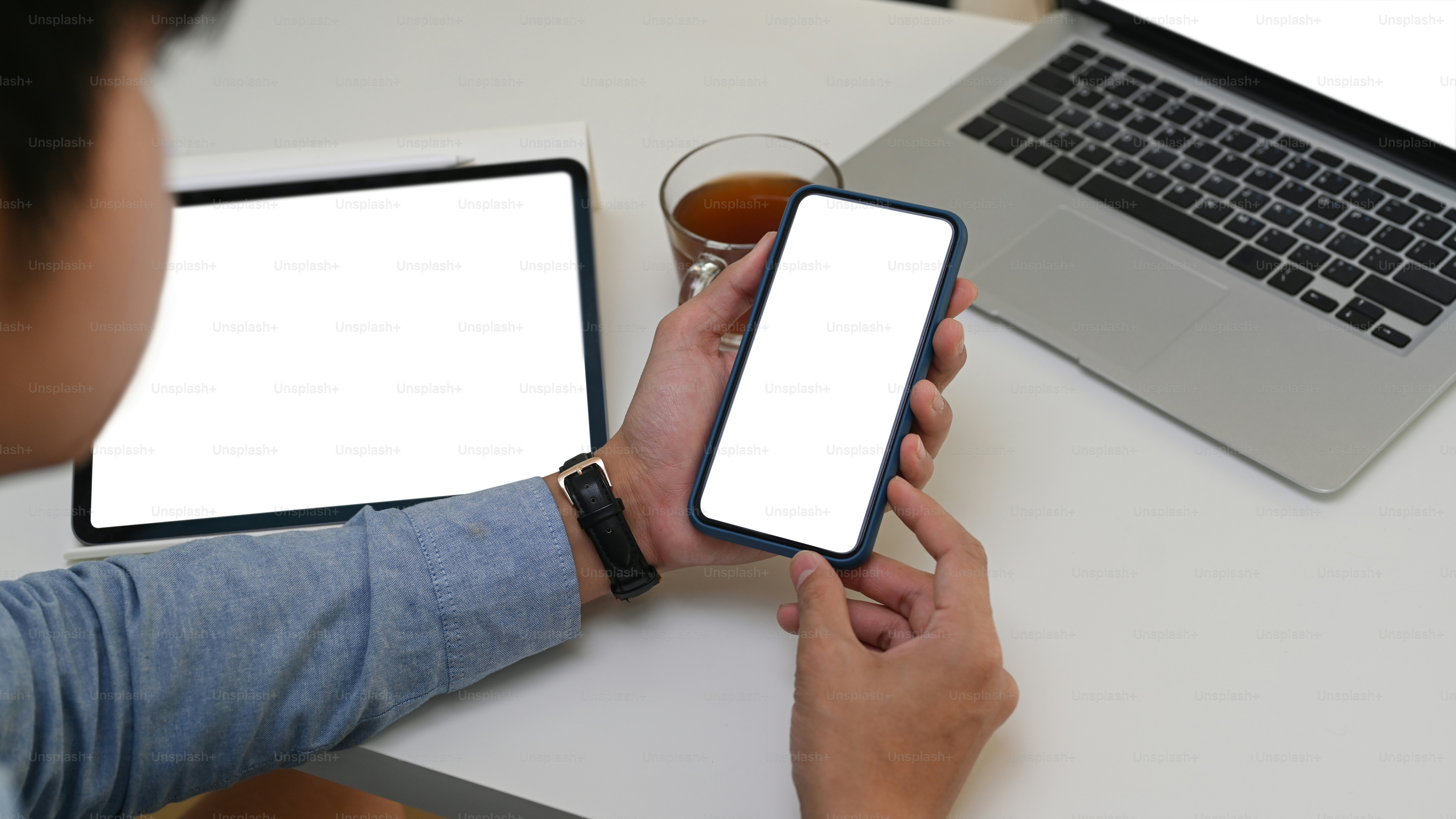 Person using a free trial on a tablet to design a patio layout while comparing with a phone showing a different app