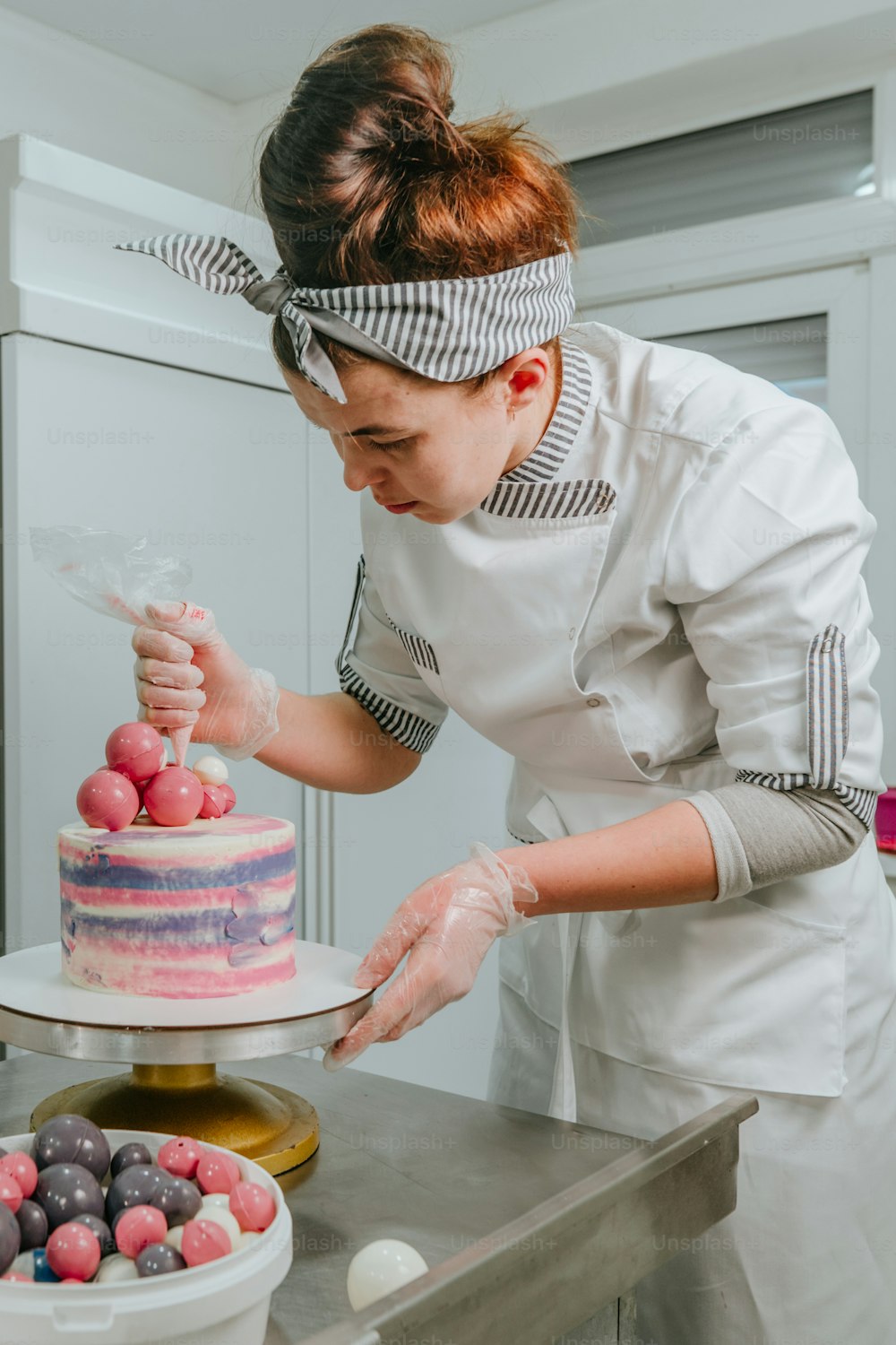 Pasticcera che decora la torta di compleanno nello studio di pasticceria