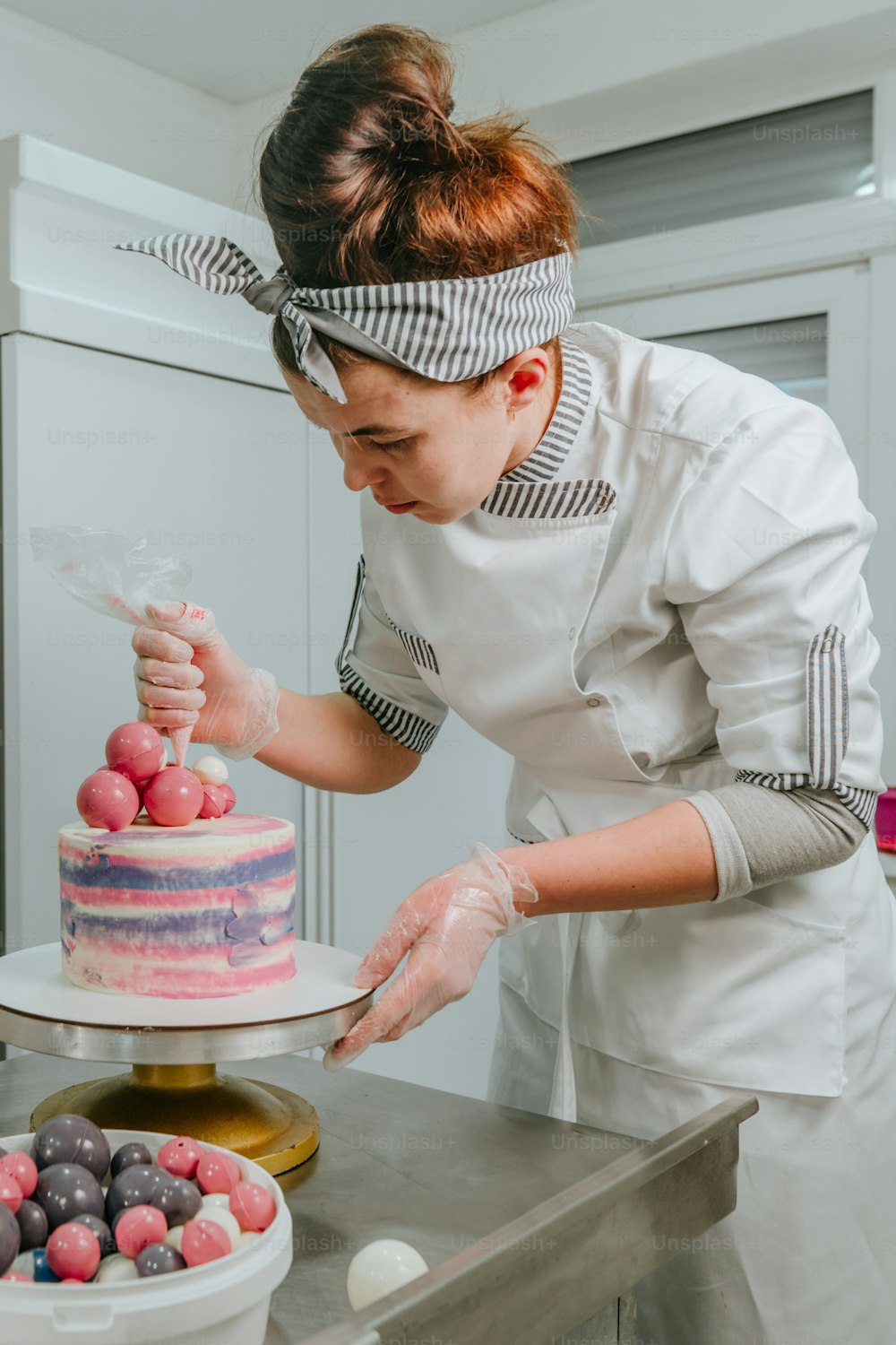 製菓スタジオでバースデーケーキを飾る女性菓子職人