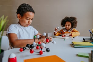 自宅で化学科学を組み立てる分子模型を作る男の子と女の子。