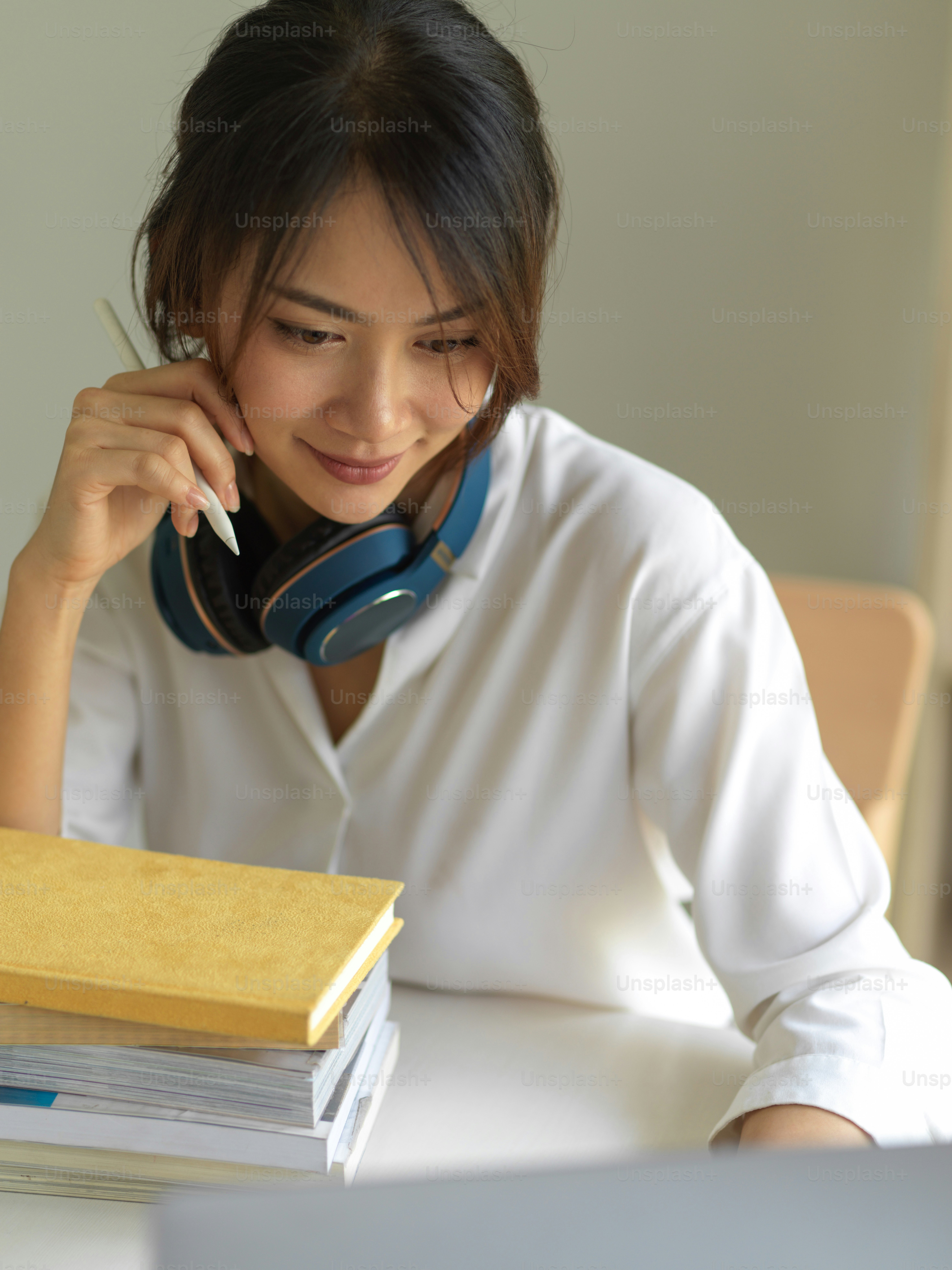 Porträt einer jungen Lehrerin, die von zu Hause aus arbeitet, Online-Unterricht auf Laptop und Büchern im Home-Office-Raum