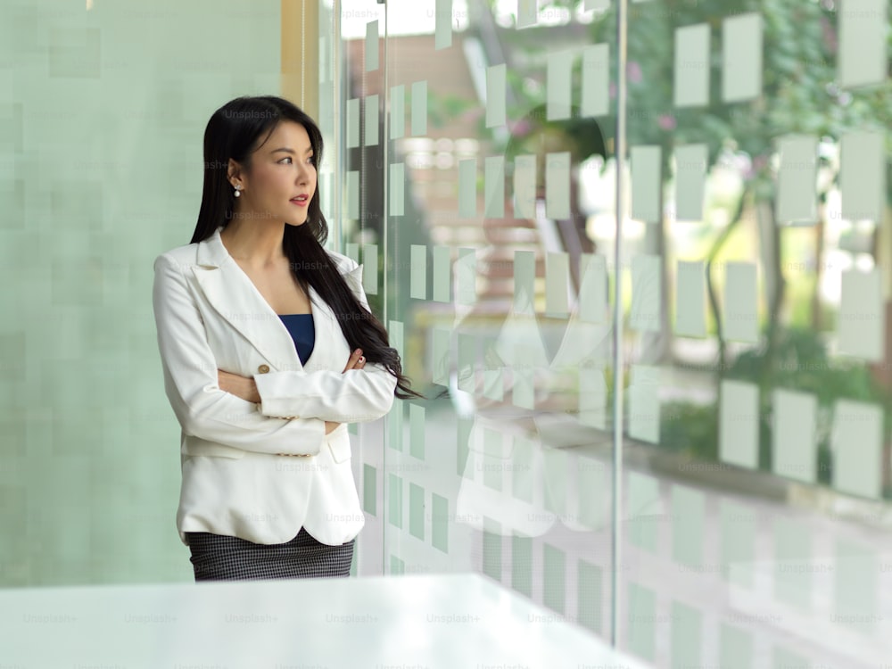 Portrait of businesswoman takes short time-out in office room and enjoying the view from office window