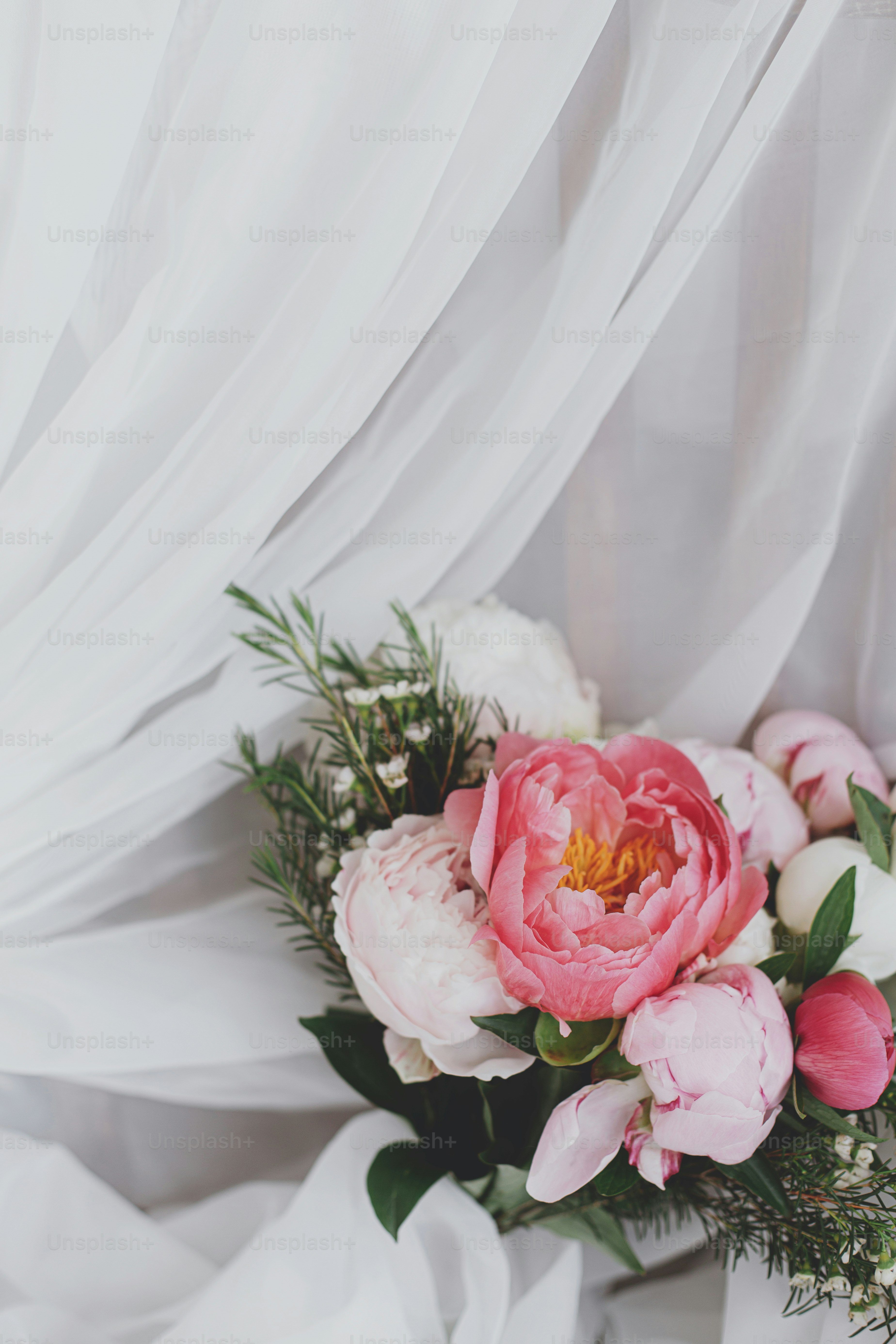 Schöne stilvolle Pfingstrosen Bouquet auf weichem weißen Stoff. Rosa und weiße Pfingstrosenblumen auf Tüll auf rustikalem Holzstuhl. Alles Gute zum Muttertag. Brautmorgen. Platz für Text