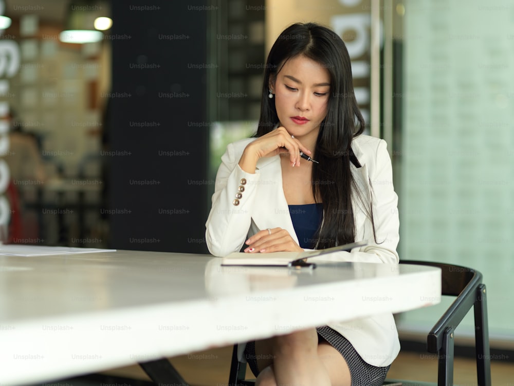 Portrait of businesswoman reading information on her notebook in meeting room