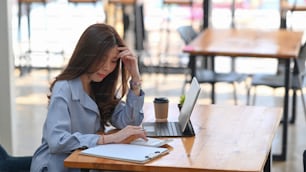 Contadora joven que usa calculadora para calcular el informe financiero y trabaja con la tableta de la computadora en la oficina.