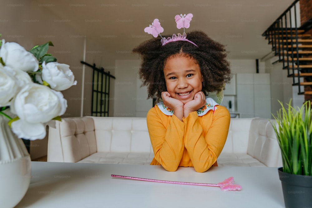 Portrait of a beautiful girl wearing costume of butterfly at home in the living room indoor.